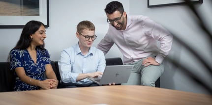 Three People Smiling Looking At Laptop