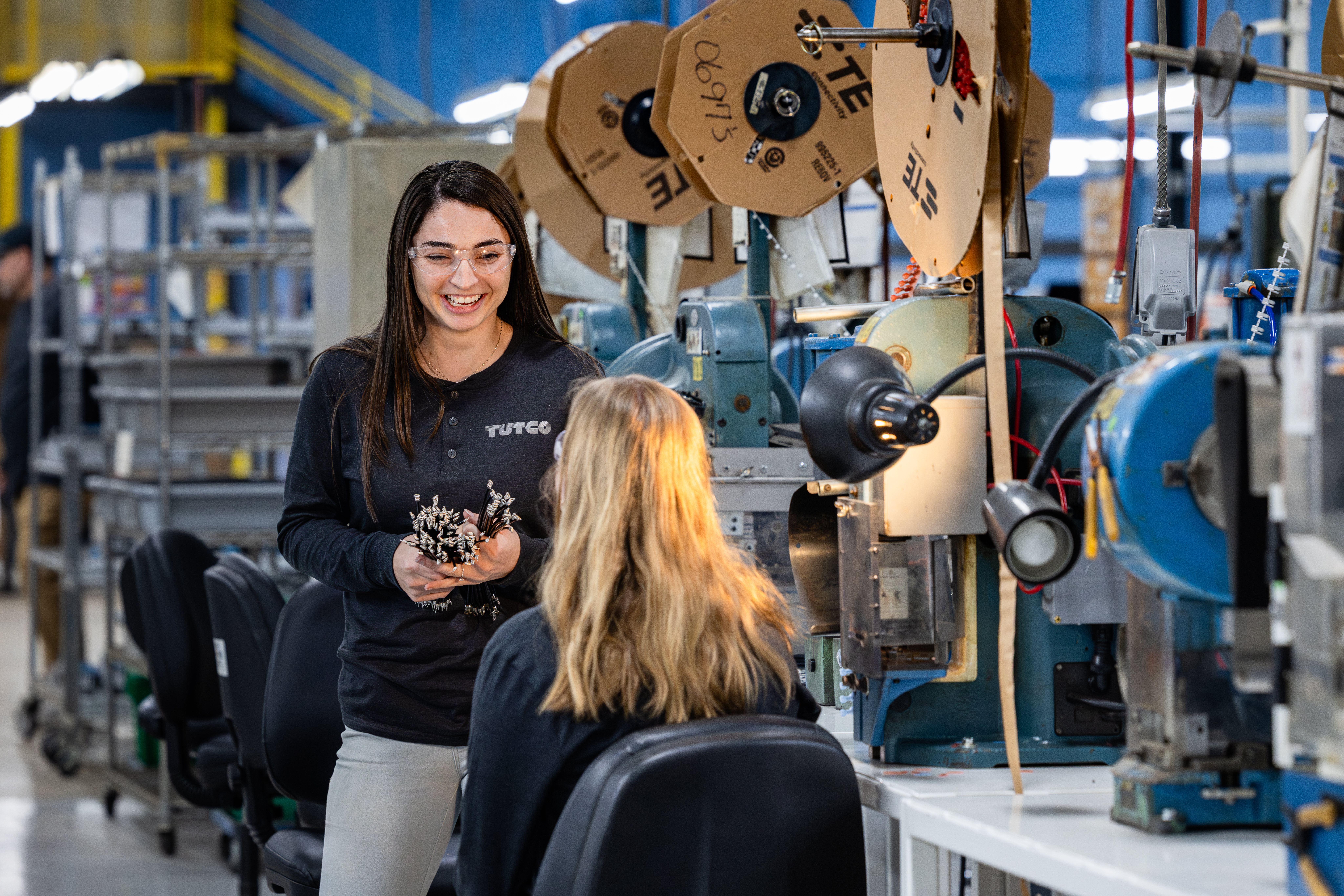 Smiling Woman Holding Products In Factory