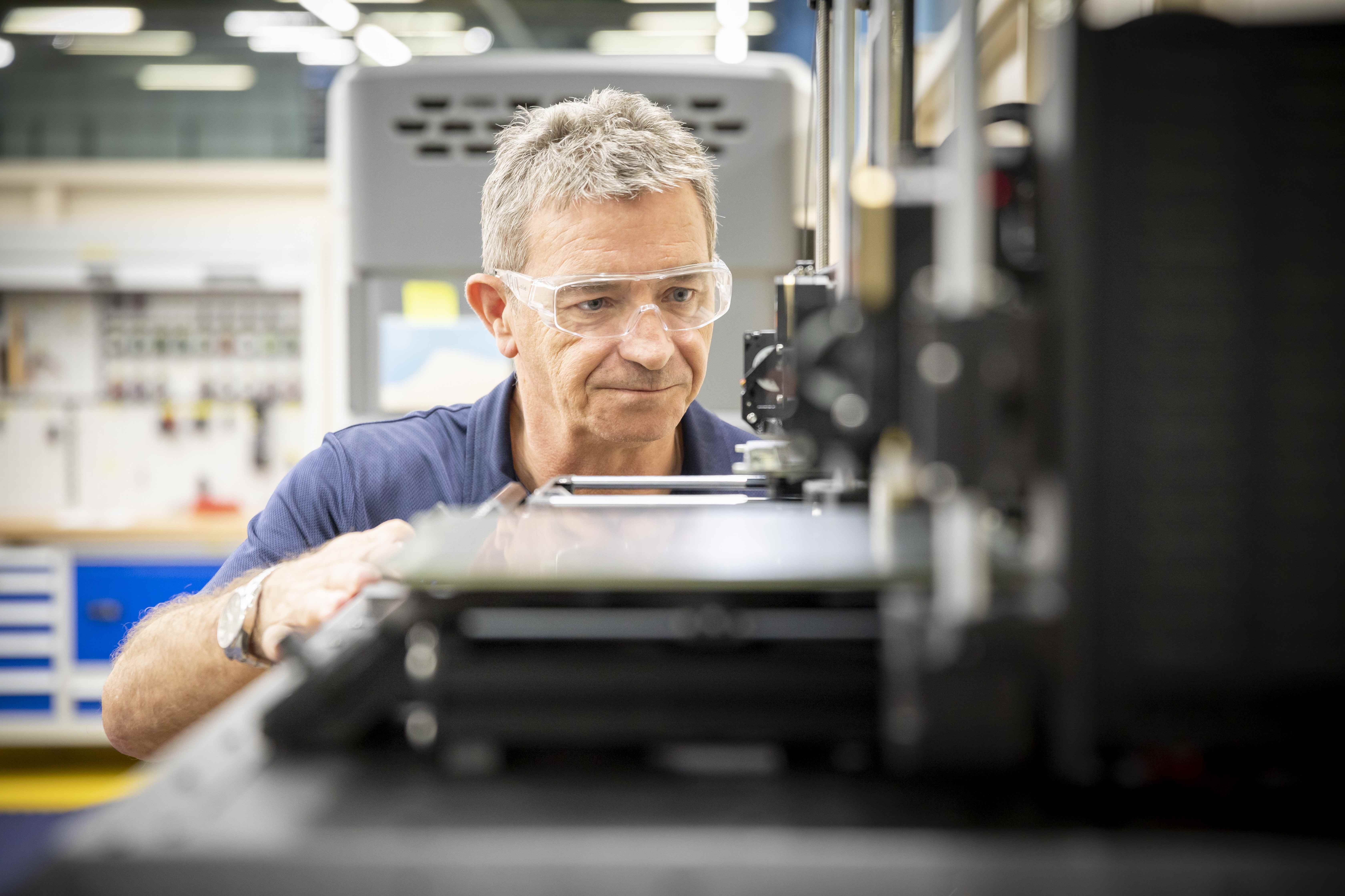 Engineer With Grey Hair Operating Machinery