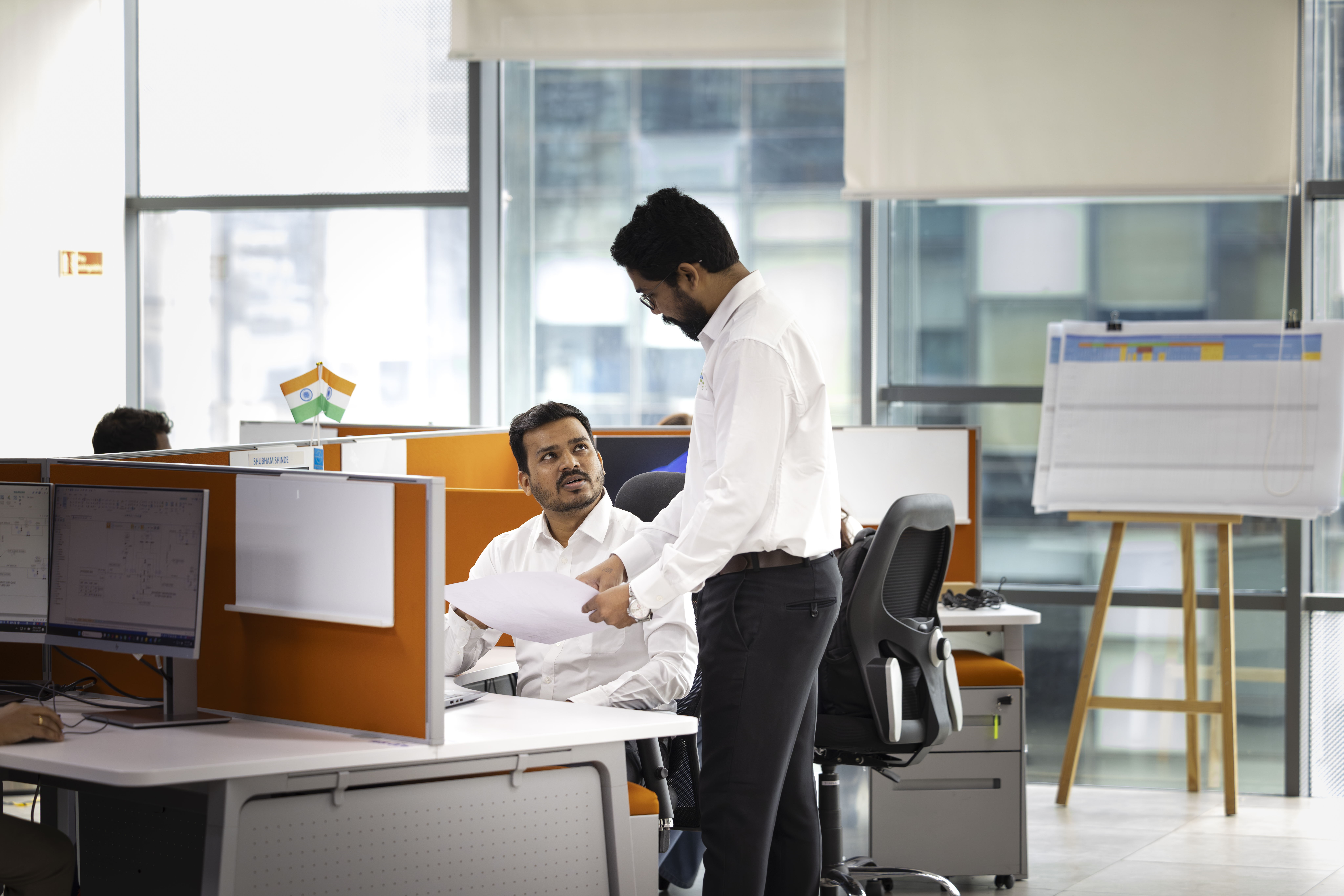 Two Men In Smart Casual Clothes In Office Having A Discussion