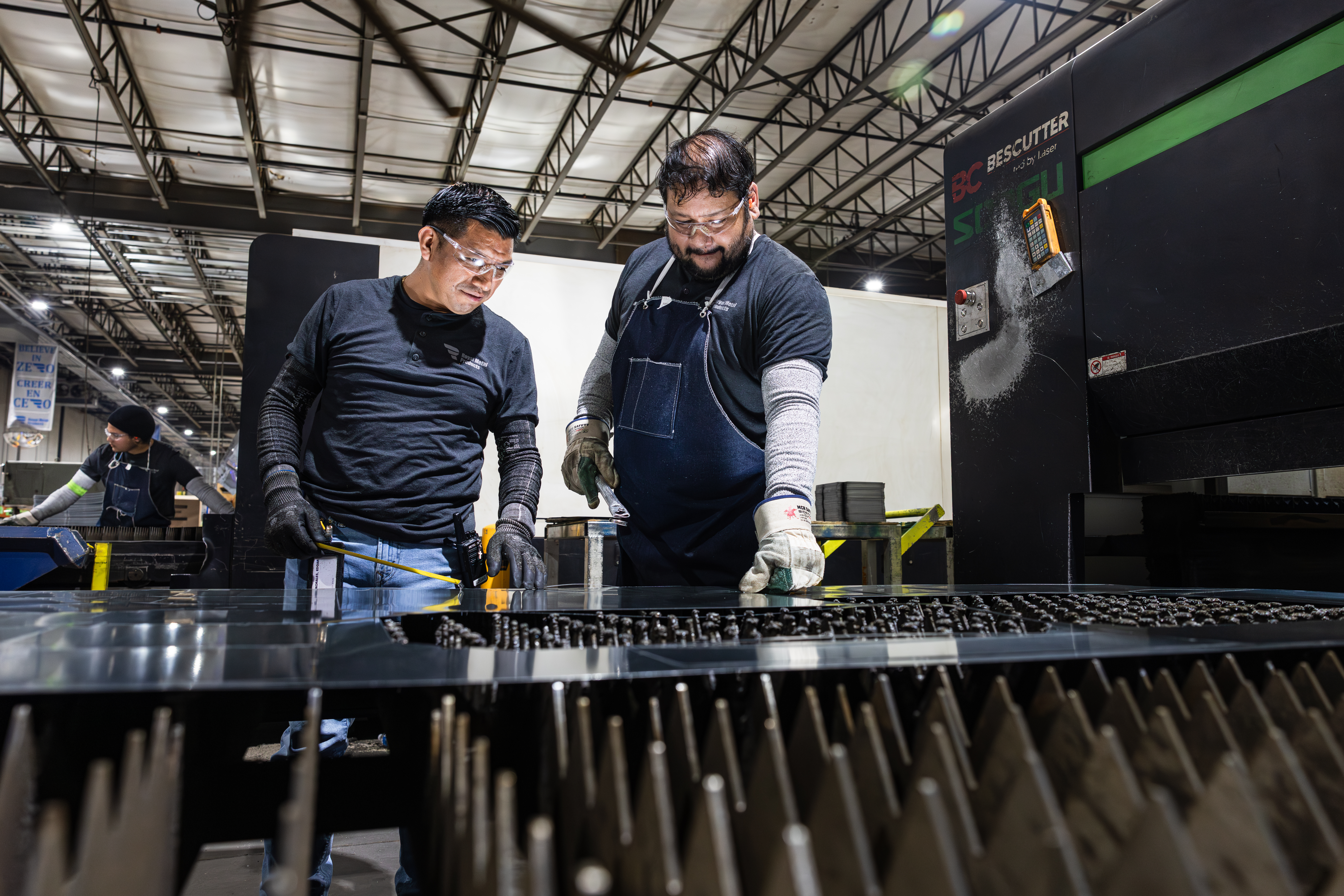 Two Employees Working At An Industrial Sheet Metal Fabrication Station